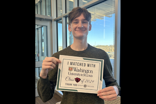 Isaiah holds his matching certificate