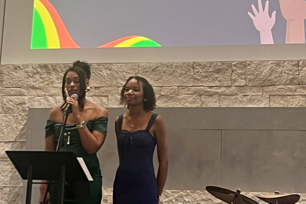 woman and girl stand at microphone on stage to address the crowd