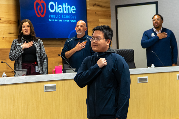 man leads Pledge of Allegiance at board meeting